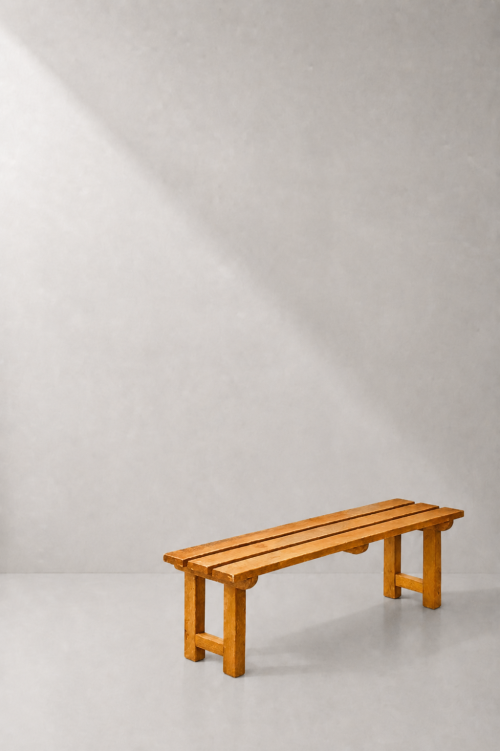 Long wooden picnic bench with a three-plank seat and warm brown finish.