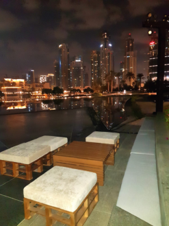 wooden pallet ottomans with wooden table against skyscrapers at night