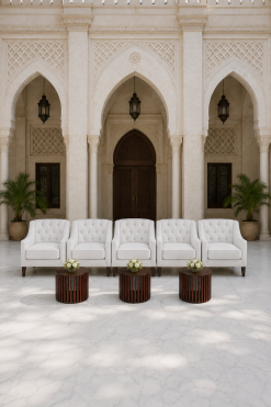 Luxury white sofas and wooden coffee tables arranged for an upscale UAE event in front of an Arabic heritage building with marble flooring.