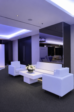 Modern white sofa and armchair lounge setup with LED ambient lighting for luxury corporate event rentals in the UAE.
