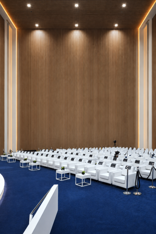Luxury white armchair seating arrangement for a corporate event in the UAE with modern lounge furniture and blue carpet setup.