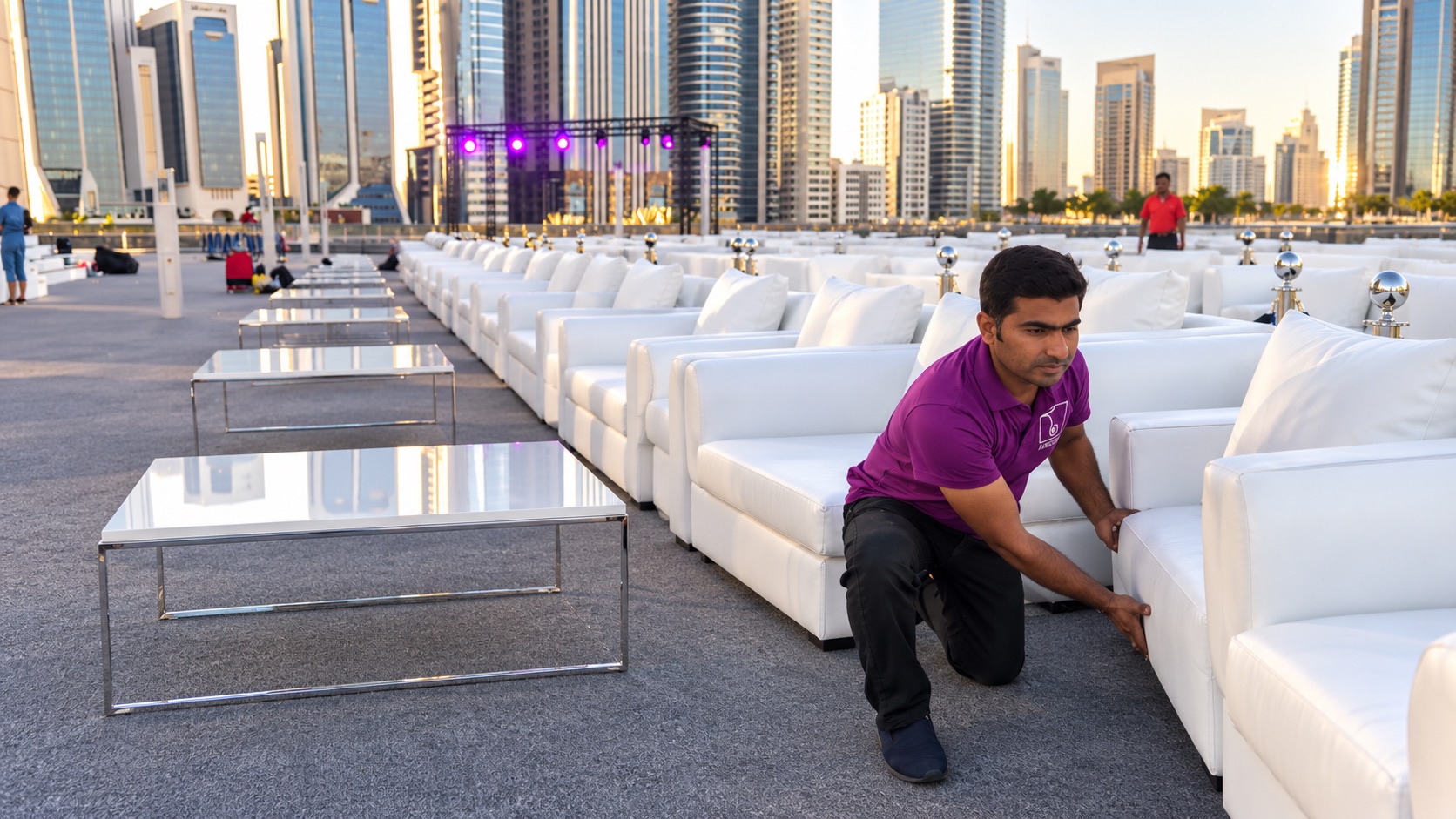 Areeka team member installing white VIP sofas for an outdoor event in Dubai